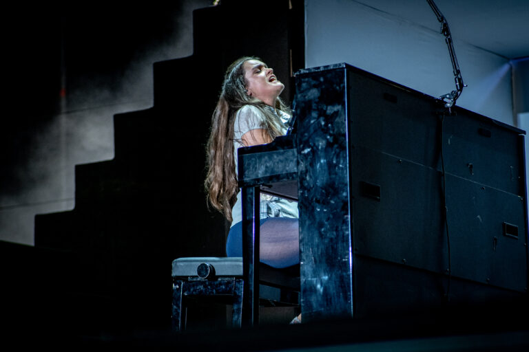 Amaia sentada al piano vertical dentro de la estructura cúbica del escenario en el Pop CAAC 2026