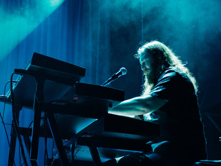David Schulthess tocando los teclados bajo una luz turquesa durante el concierto de Morgan en Sevilla
