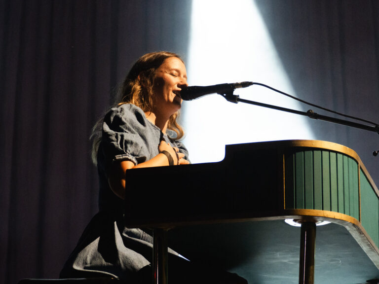 Nina de Juan al piano con un haz de luz blanca abriéndose detrás en el Patio de la Diputación de Sevilla