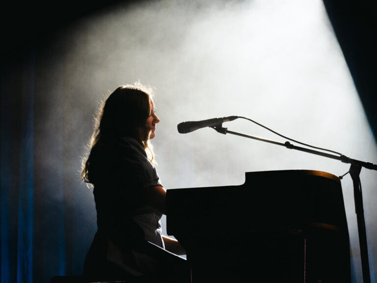 Nina de Juan de perfil al piano, recortada a contraluz entre el humo del escenario, en el concierto de Morgan en Sevilla