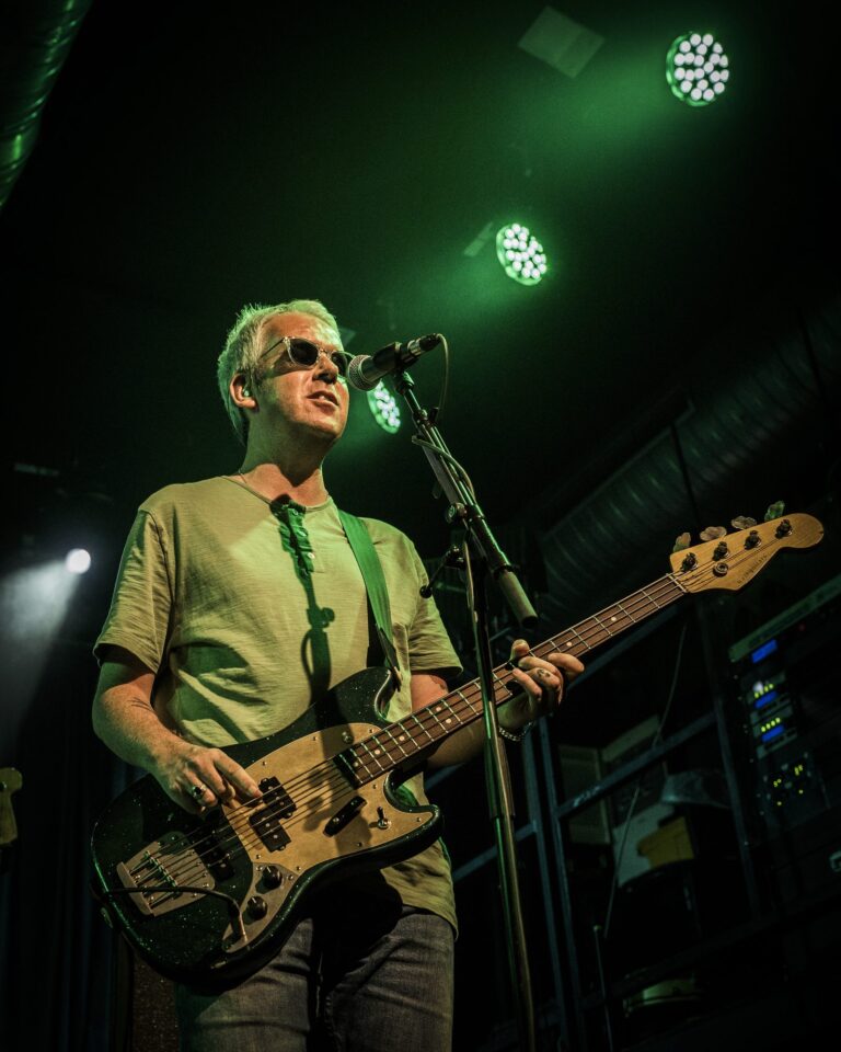 El bajista de Ocean Colour Scene tocando y cantando bajo luz verde en la Sala Custom de Sevilla