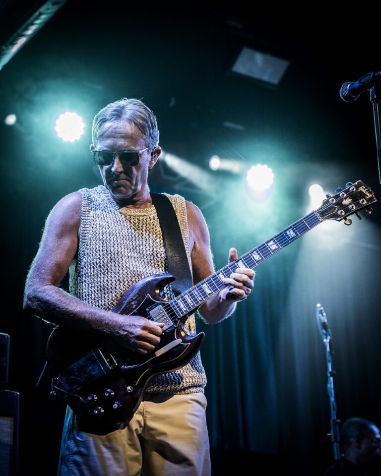 Steve Cradock tocando la guitarra entre el humo y los focos del escenario en el concierto de Ocean Colour Scene en Sevilla
