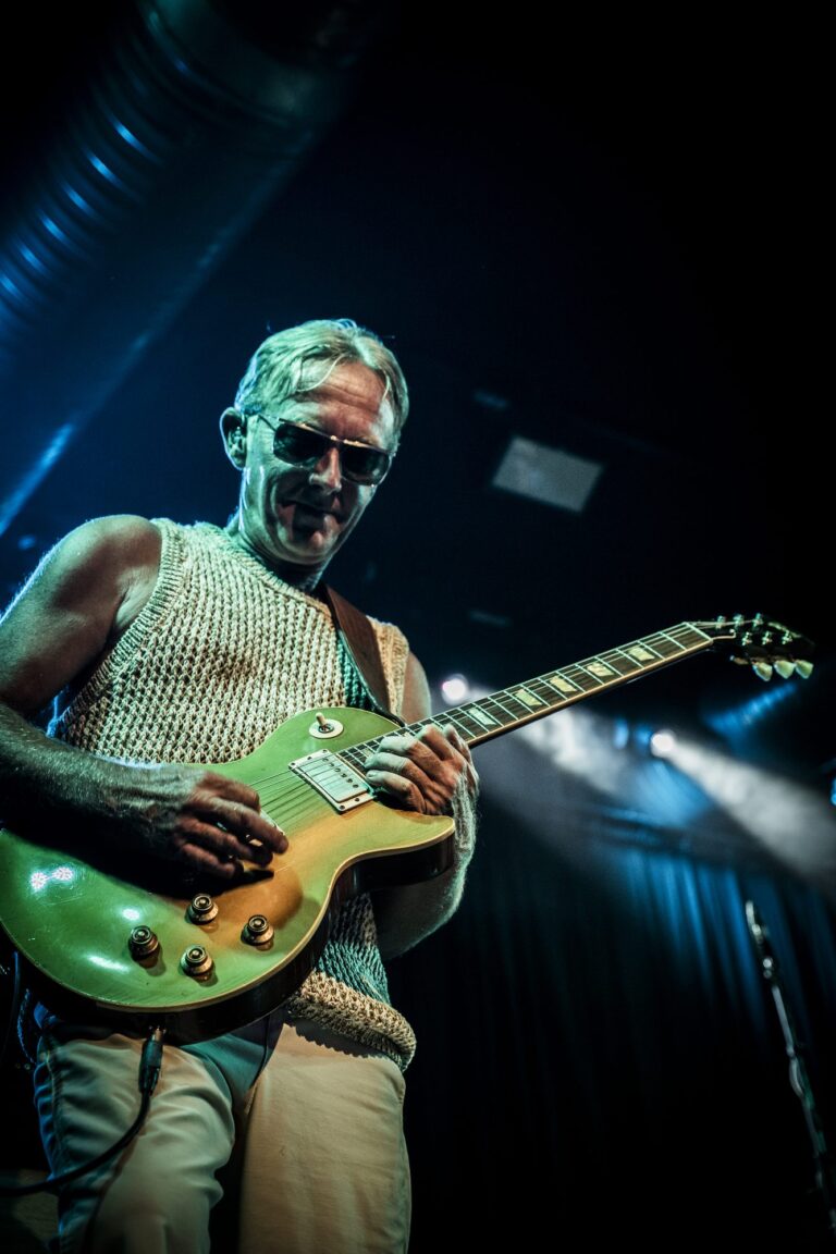 Steve Cradock sonriendo con su Les Paul bajo luz verde en el concierto de Ocean Colour Scene en Sevilla
